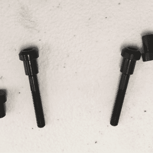 A set of four black bolts sitting on top of a wall.