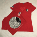 A red shirt and a silver t-shirt with an image of the statue of liberty.