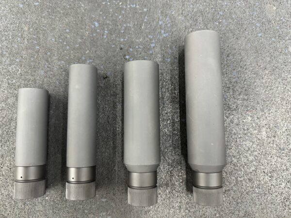 A group of four grey metal tubes sitting on top of a floor.