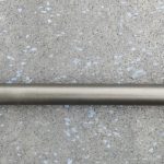 A metal rod sitting on top of a concrete floor.