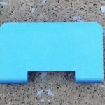 A blue piece of plastic sitting on the ground.