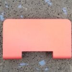A pink plastic object sitting on the ground.