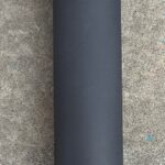 A black tube sitting on top of the ground.