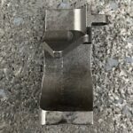 A metal object sitting on top of a gravel surface.